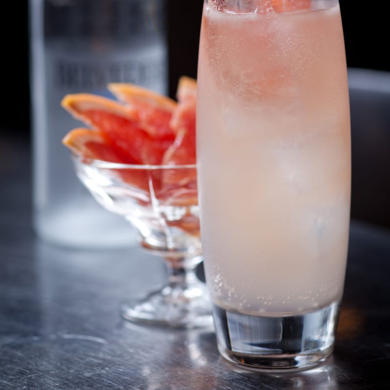 cocktail, glass of sliced citrus and belvedere vodka bottle